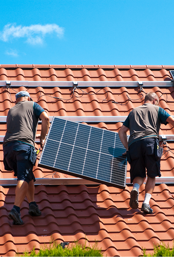 image de homme portant un panneau solaire sur le toit